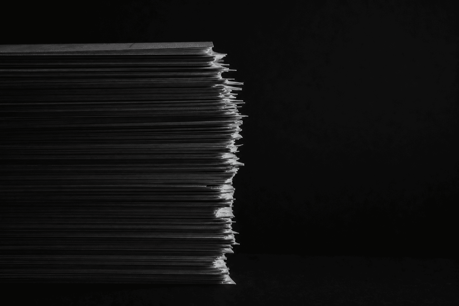 A thick stack of printed statements, lit from one side